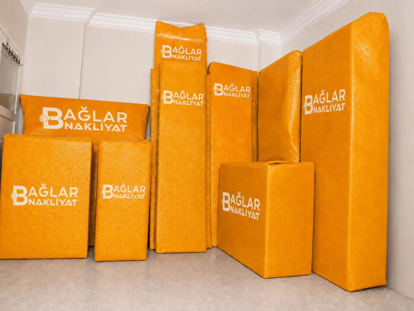 Boş odada düzenli şekilde sıralanmış paketli mobilyalar