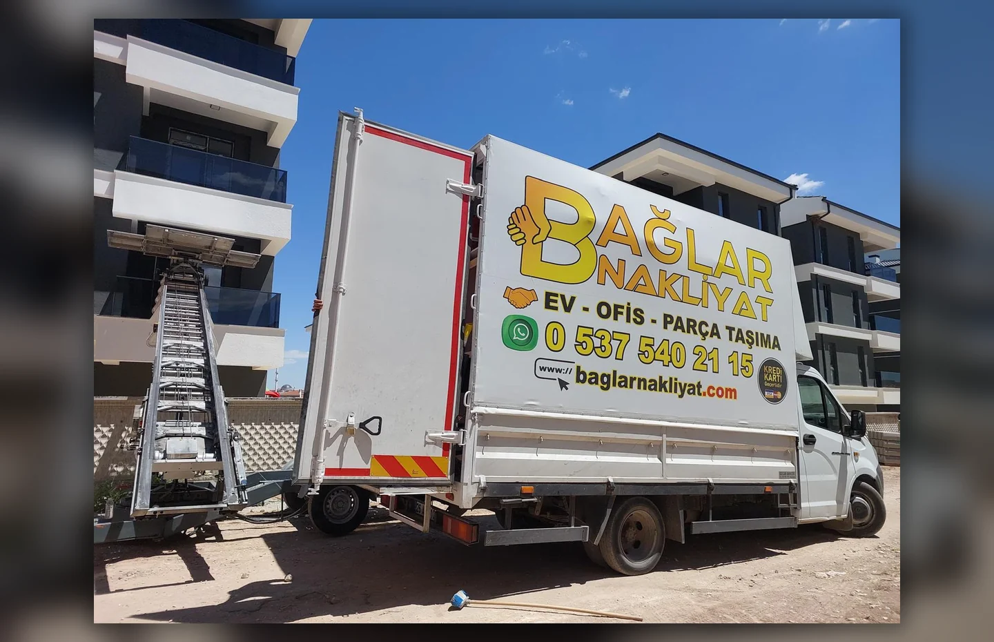 Apartman önünde Bağlar Nakliyat kamyonu ve dış cephe taşıma asansörü