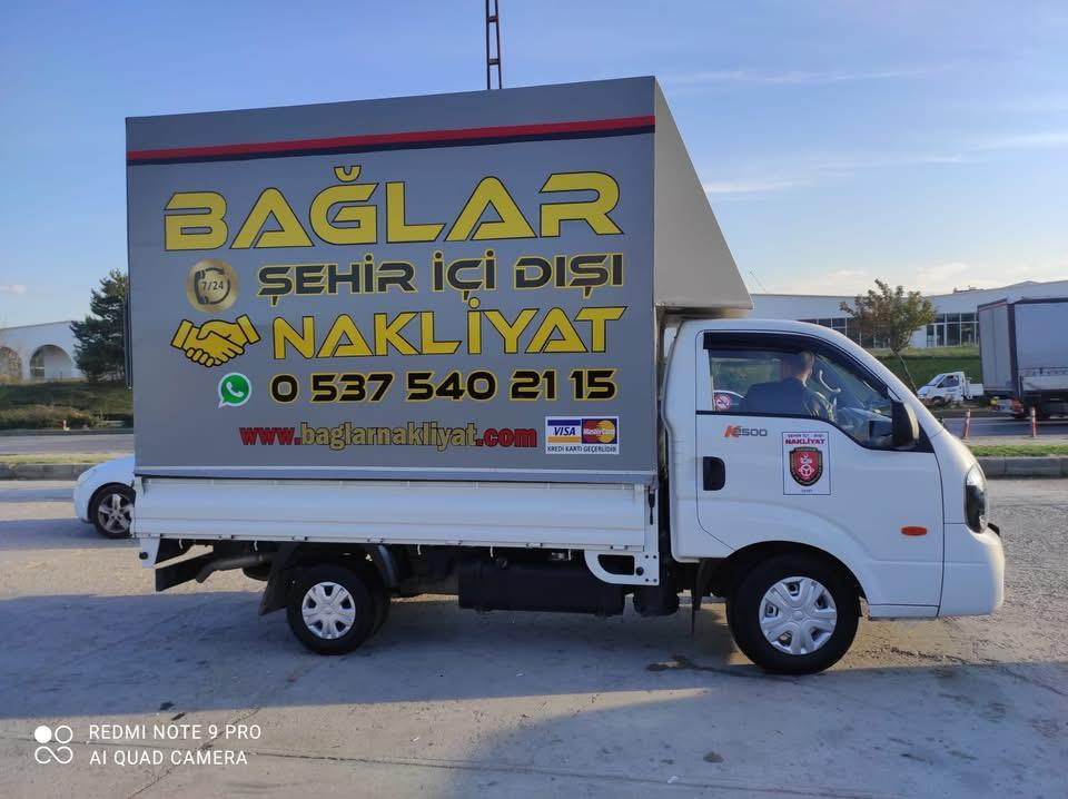 Bağlar Nakliyat yazılı beyaz kapalı kasa parça eşya taşıma aracı, yandan görünüm